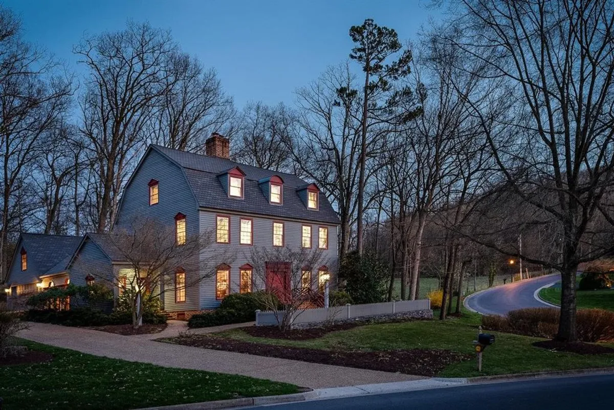 Colonial home at twilight with warm interior lighting on tree-lined street in Fairway Hills, Harrisonburg VA