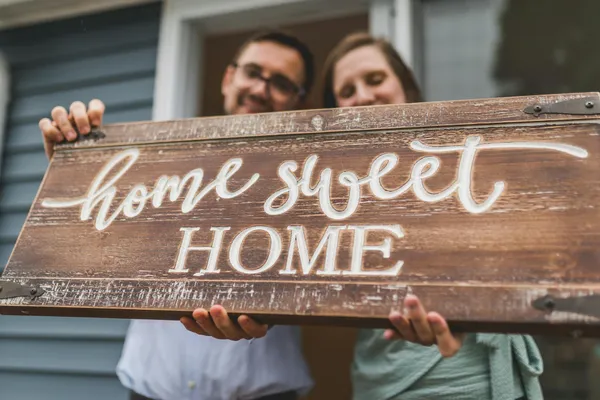 Young couple reviewing documents while standing in front of their new home in Harrisonburg, Virginia
